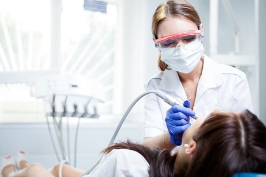Tandläkare undersöker en kvinnlig patient.