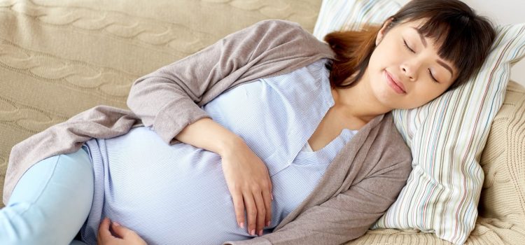 Gravid kvinna sover på sidan
