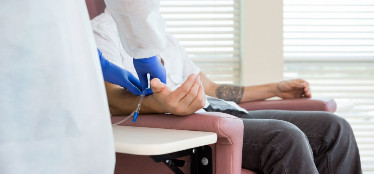 Patient i stol får cytostatika mot cancer genom nål i armen.