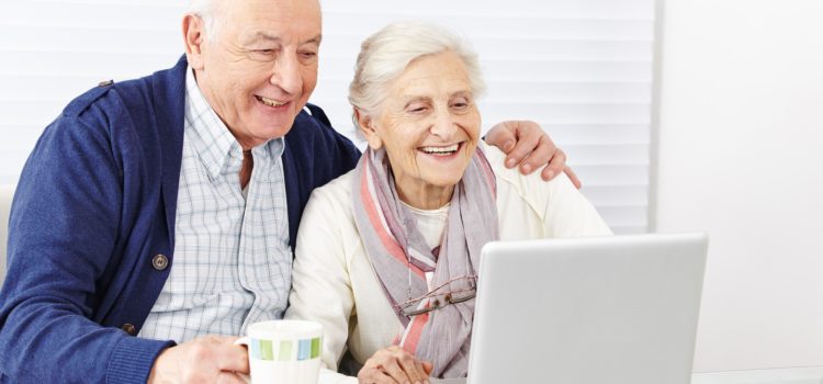 Äldre par sitter vid en laptop
